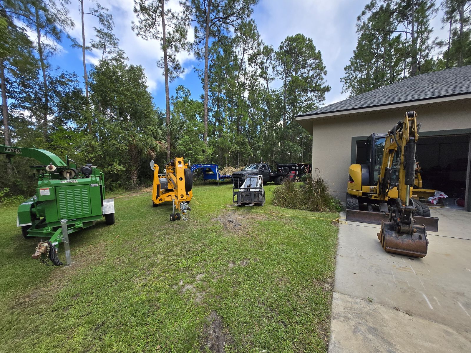 Wood chipper, boom lift, and excavator for tree removal in Eustis, FL Wood chipper, boom lift, and excavator for tree removal in Eustis, FL